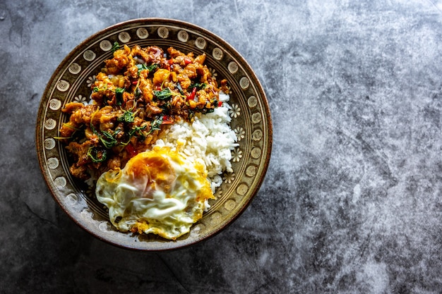 写真 豚肉または牛肉の目玉焼き、タイ料理をトッピングしたバジルライスの上面図