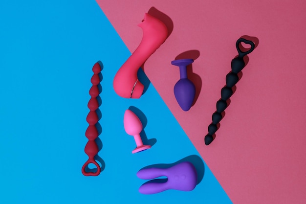 Фото Вид сверху на анальные пробки и фаллоимитаторы для секса на цветном фоне концепции секс-шопа