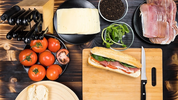 사진 보드에 있는 맛있는 샌드위치와 샌드위치가 만들어진 모든 재료의 평면도