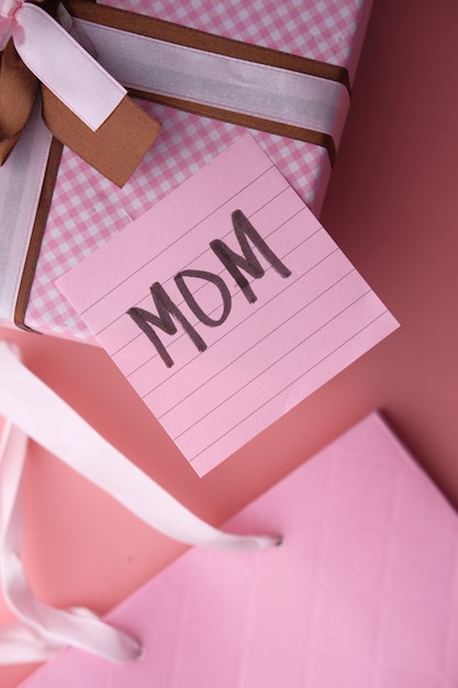 Вид сверху подарка на день матери на розовом фоне