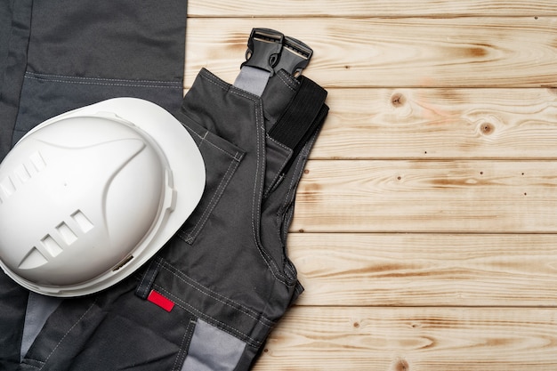 写真 木製の背景に建設労働者の制服の上面図
