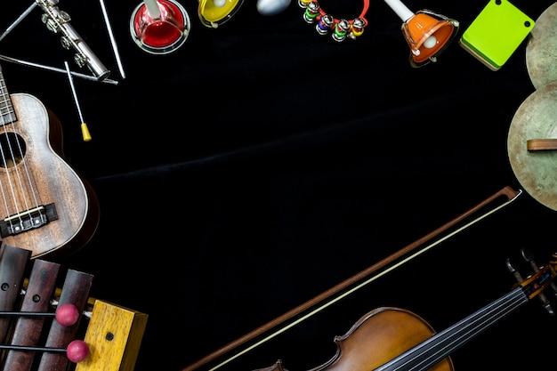 Фото Вид сверху на скрипке гитары и укулеле с ударными инструментами на черном фоне