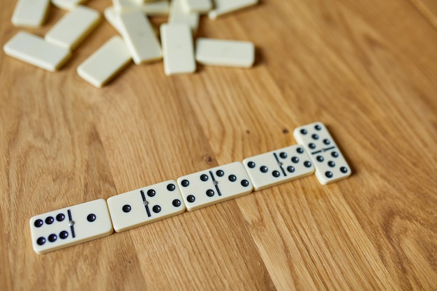 写真 コピースペースボードゲームのコンセプトと木製のテーブルの背景に白いドミノゲームの上面図