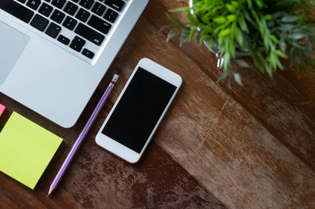 Top view of office desk table with laptop phone flower and yellow stickers