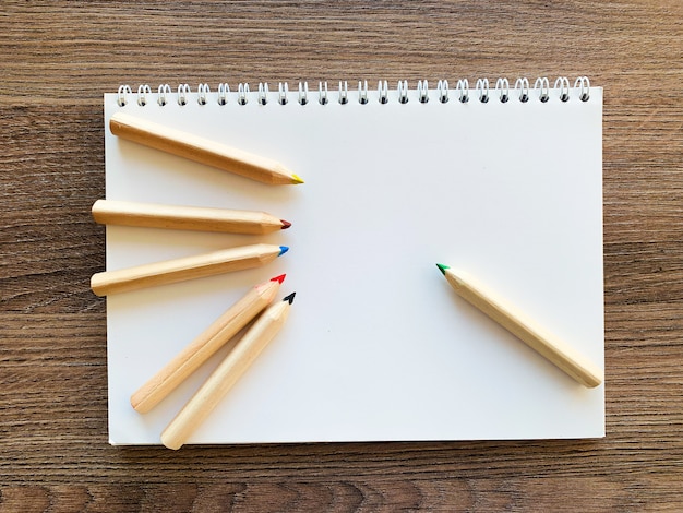 Top view office desk with Empty notebook and pencils on wood table