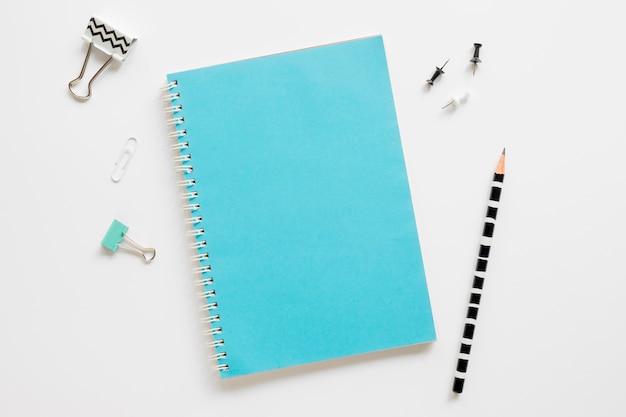 top view of office stationery with notebook and paper clips