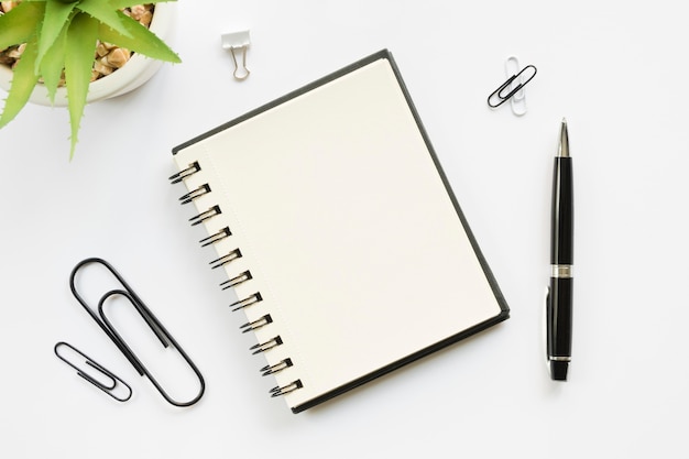 top view of office stationery with paper clips and notebook
