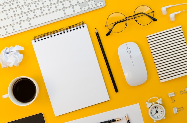 Top view of office supplies with mouse and glasses