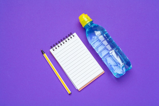 Top view of office supplies with water bottle