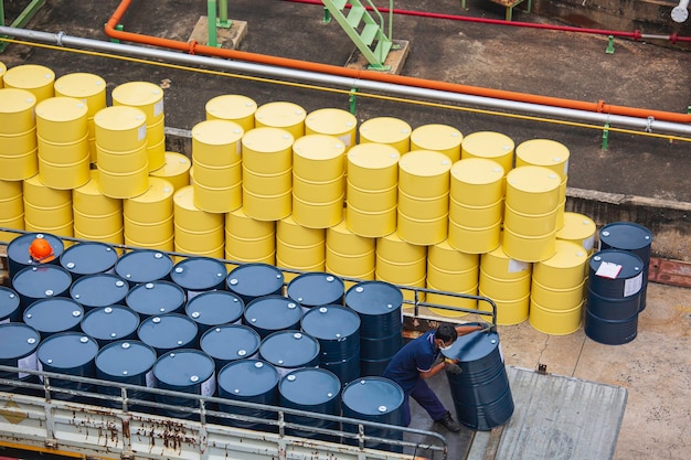 Top view oil barrels forklift truck move for on the transportation truck male worker help arrange.