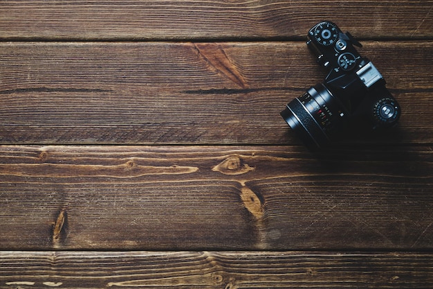 Top view of an old camera on wooden boards and a place for your text