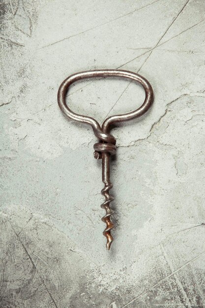 Top view of an old cork screw on gray concrete background