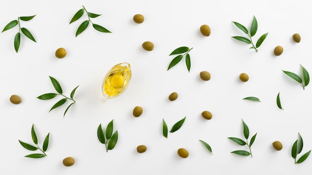 Top view olive oil in a bottle with leaves