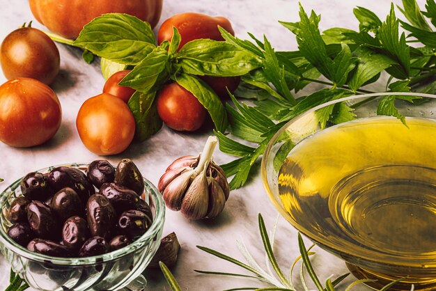 Top view of olive oil and fresh healthy vegetables on marble table