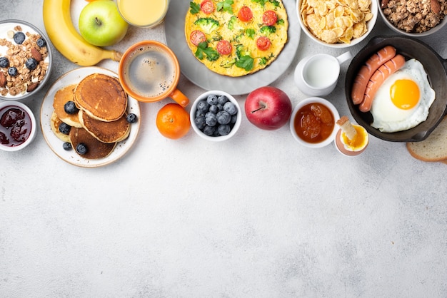 Foto vista dall'alto di frittata con uovo e salsiccia e assortimento di cibi per la colazione