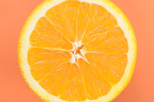 오렌지 색상의 밝은 배경에 한 오렌지 과일 조각의 상위 뷰