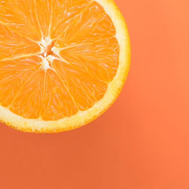 오렌지 색상의 밝은 배경에 한 오렌지 과일 조각의 상위 뷰