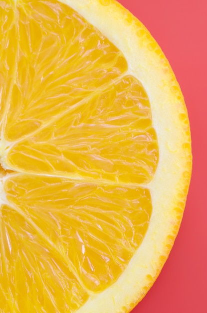 Top view of a one orange fruit slice on bright background in red color