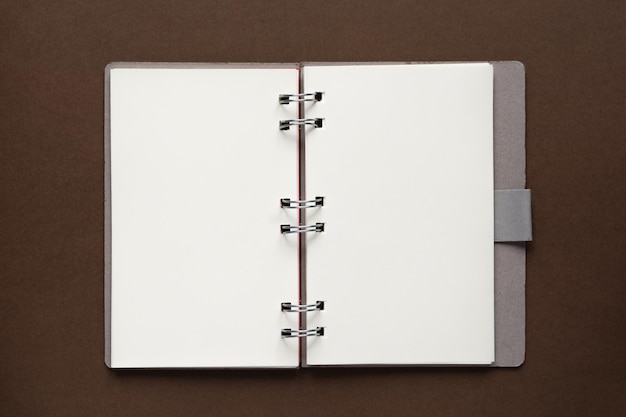 Photo top view of open empty notebook with cover from recycled paper on brown background