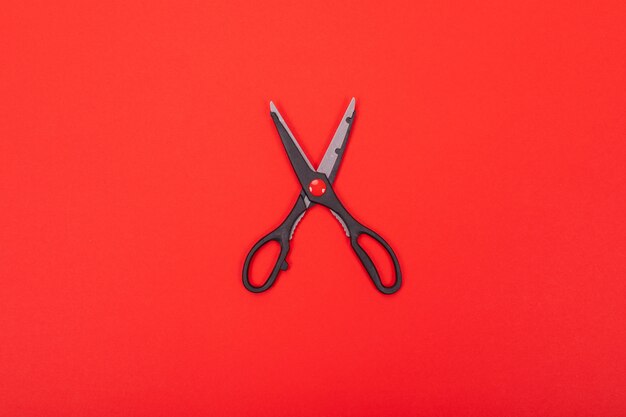 Top view of open scissors isolated on red 