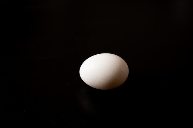 Top view of opened box with eggs on black background.