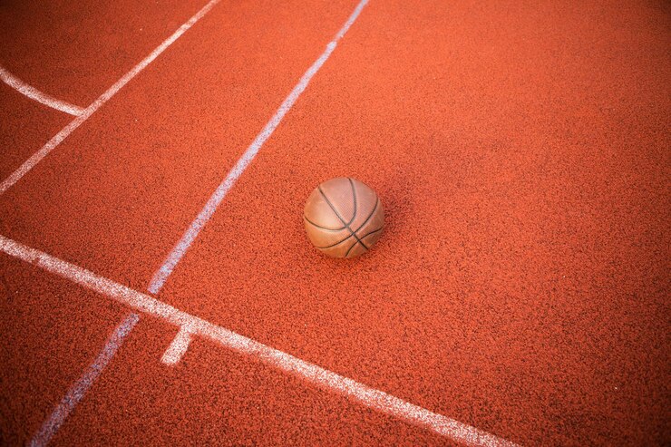ゴム スポーツ コートに横になっているバスケット ボールのトップ ビュー オレンジ色のボール。スポーツレッドグラウンドアウトドア