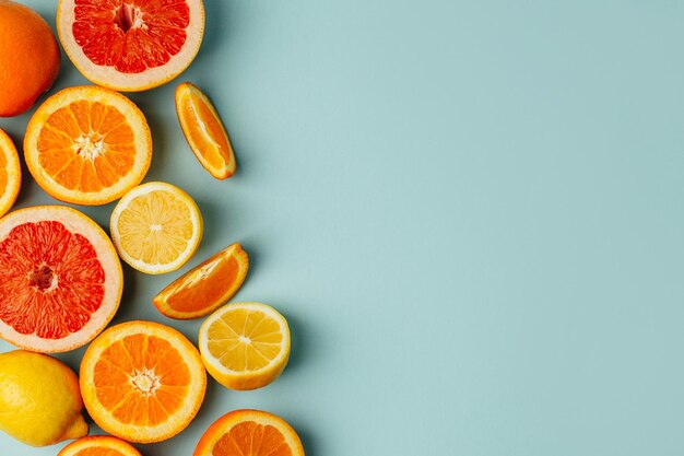 Photo top view of orange grapefour and lemon citrus fruits with herbs on blue background