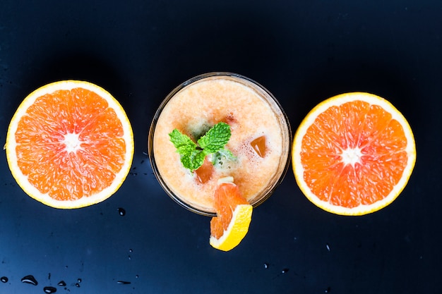 Top view of orange juice with mint and oranges