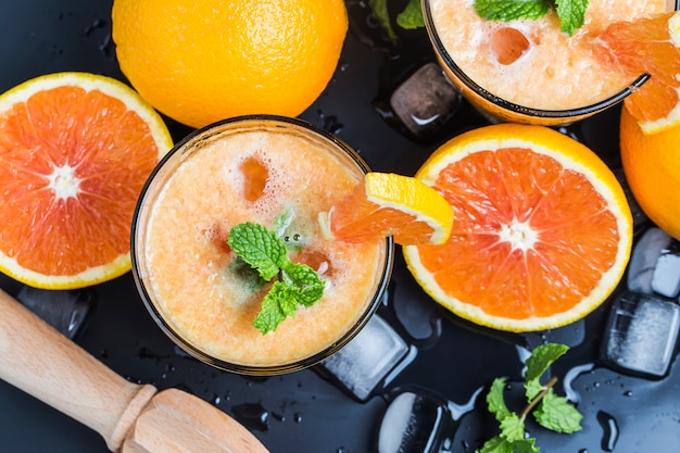 Top view of orange juices and oranges