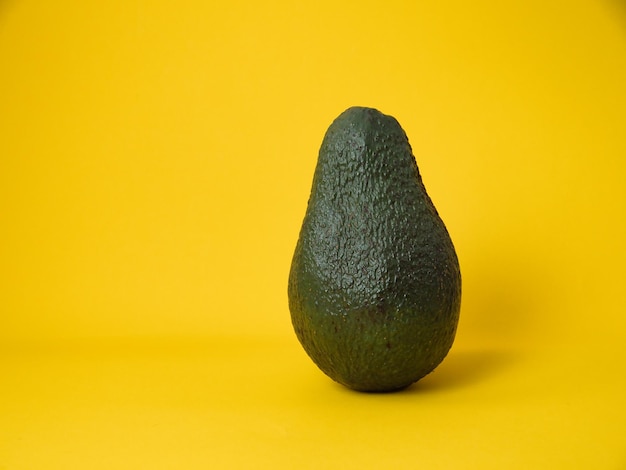 Верхний вид органического зеленого авокадо на желтом фоне прохладное минимальное плоское пространство для копирования