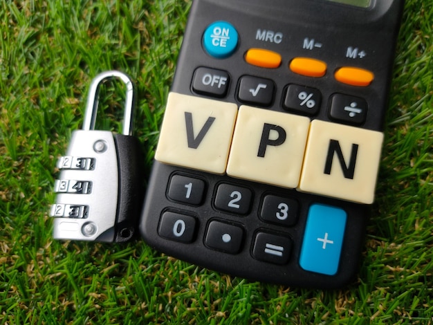 Top view padlockcalculator and toys word with text vpn on a green grass background