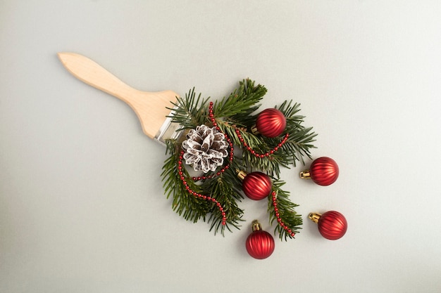 Top view of paintbrush with Christmas composition on the gray background. Close-up.