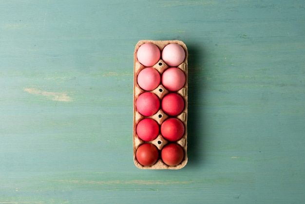 Top view of painted easter eggs in cardboard carrier on textured surface