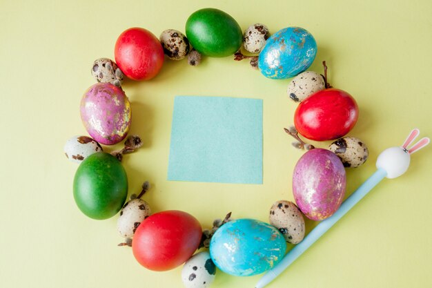 Top view painted eggs Easter Frame in circle shape on a yellow background. Copy space