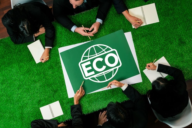 상단에서 볼 수 있는 파노라마 ECO 상징은 사업가들과 함께 잔디 테이블에 있습니다.