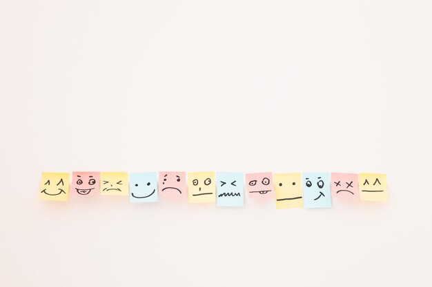 Top view of paper cards with various smileys on white background