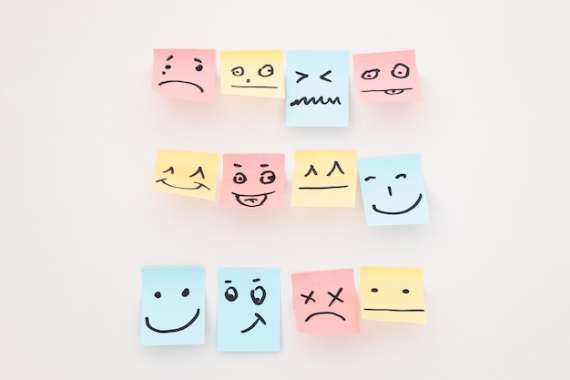 Top view of paper cards with various smileys on white background