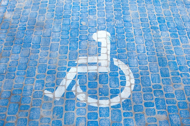 Foto vista dall'alto sul segno di parcheggio per disabili. parcheggio per disabili e simboli di sedie a rotelle su pavimentazione