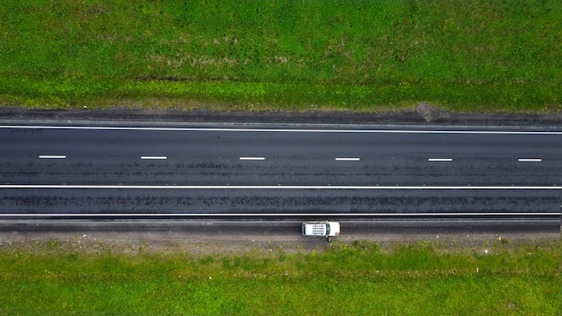 top view. part of the highway in spring. along the green fields. on a road section a car is parked