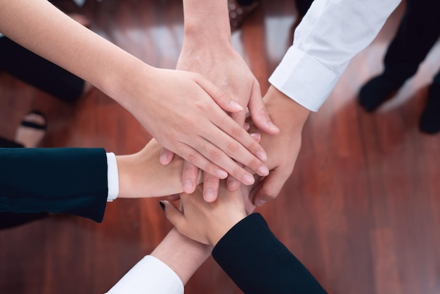 Top view partial hand join stack and form circle as symbol of harmony in office