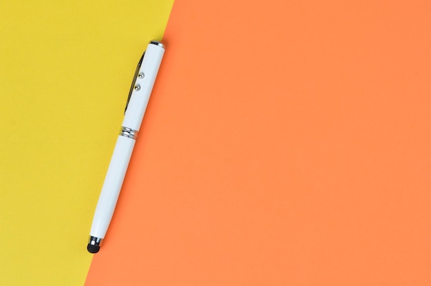 Top view of pen over yellow and orange paper with copy space business concept