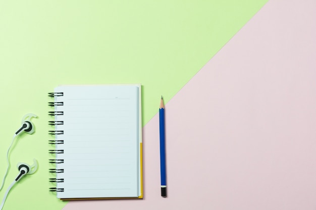 Top view of pencil and notebook on colorful background 