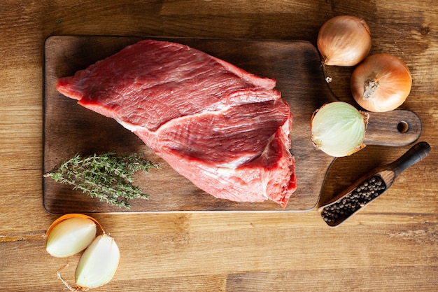 Fagioli di pepe vista dall'alto accanto a un grosso pezzo di carne rossa sul taglio vintage. copia spazio disponibile.