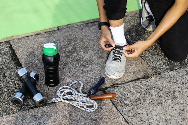 Vista dall'alto della persona che lega le scarpe che si prepara per le routine di allenamento