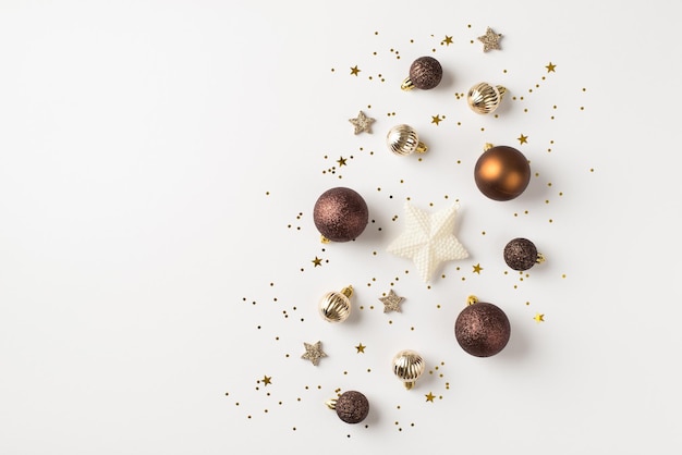 Top view photo of brown white silver and golden christmas tree decorations balls shiny stars and confetti on isolated white background with copyspace