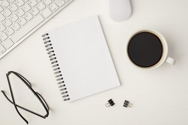 Top view photo of business workplace with keyboard mouse cup of coffee binders glasses notebook with copyspace on isolated white background