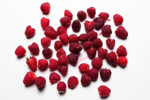 Top view photo of fresh raspberries spread on the white background.