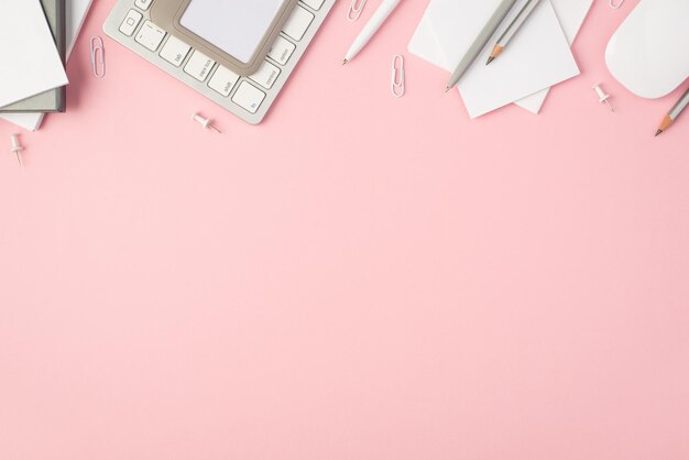 Top view photo of grey stationery reminders pens pencils clips pins stickers id keyboard and mouse on isolated pastel pink background with copyspace