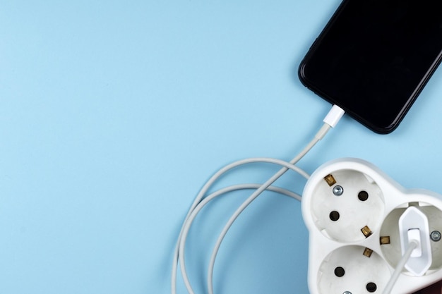 Top view photo of hand holding smartphone charging