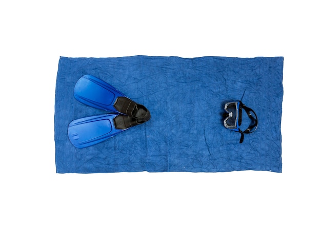 Top view photo of snorkeling equipment lying on blue beach towel